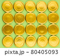 Lids for jars of gold color top view on a green background. 80405093