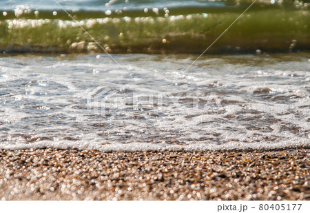 coastline with waves and small shells in the sunshine 80405177