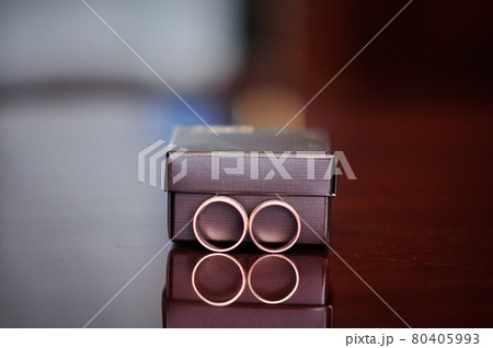 Two wedding rings near the gift box.  80405993