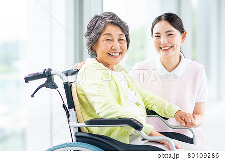 車いすの高齢者と若い介護福祉士 80409286