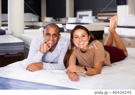Couple lying on new mattress in store 80410245