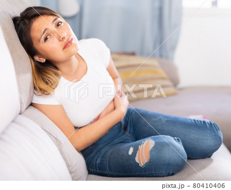 Latino woman experiencing pain in the stomach Latino woman experiencing pain in the stomach 80410406