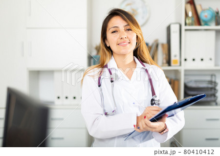 Doctor making notes on clipboard 80410412