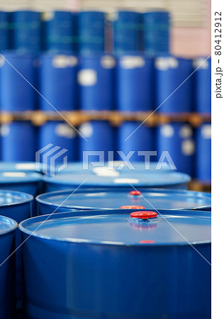 Red cap on blue chemical barrels.  Many barrels line up in the background. 80412912