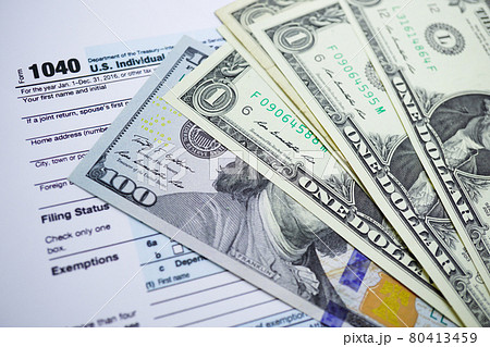 Tax Return form 1040 and dollar banknote : U.S. Individual Income. 80413459