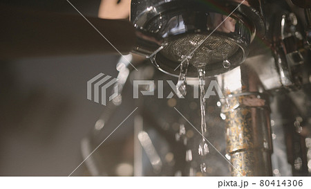 Rinsing coffee machine before making espresso under morning light Rinsing coffee machine before making espresso under morning light 80414306