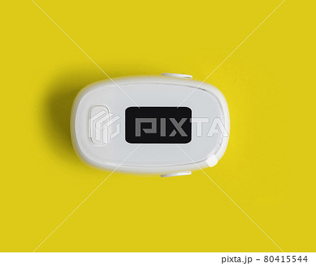 Pulse oximeter or blood oxygen level measure monitor device isolated on yellow background. Diagnosis self check up. Medical and healthcare equipment. Coronavirus covid-19 outbreak. 80415544