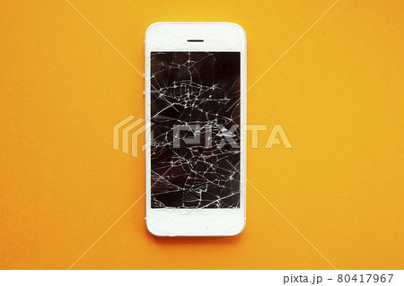 Broken screen of smartphone on the orange background 80417967
