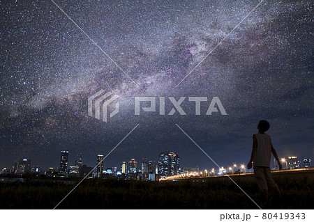 【野心を抱くイメージ】都会の片隅で満点の星空を見上げる青年 80419343