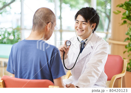 介護施設で診察をする男性医師 介護施設で診察をする男性医師 80420123