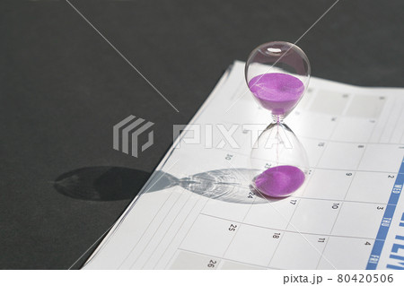 Hour glass sand and calendar on black tabletop background. 80420506