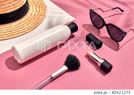 Woman's accessories lying flat on textured paper background. Pink and white pastel colors with copy space around products. 80421275
