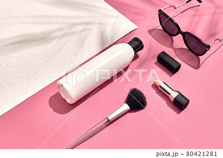 Woman's accessories lying flat on textured paper background. Pink and white pastel colors with copy space around products. 80421281