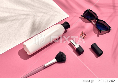 Woman's accessories lying flat on textured paper background. Pink and white pastel colors with copy space around products. Woman's accessories lying flat on textured paper background. Pink and white pastel colors with copy space around products. 80421282