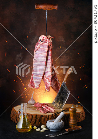 Raw lamb ribs on hook over wooden stumb Raw lamb ribs on hook over wooden stumb 80421791