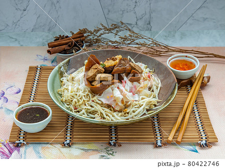 Braised pork, tofu, crisp squid in sweet soy sauce served on Chinese steamed rice noodles and bean sprout in ceramic plate. Braised pork, tofu, crisp squid in sweet soy sauce served on Chinese steamed rice noodles and bean sprout in ceramic plate. 80422746