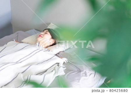 ベッドで熟睡する若い女性 80425680