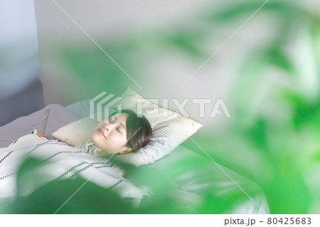 ベッドで熟睡する若い女性 80425683
