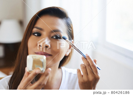 Woman Looking at Compact Mirror Woman Looking at Compact Mirror 80426186