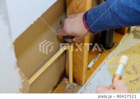 Man manual cuts off a piece of polypropylene pipes for installation water line Man manual cuts off a piece of polypropylene pipes for installation water line 80427521