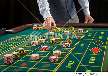 Picture of a green table and betting with chips. 80428239