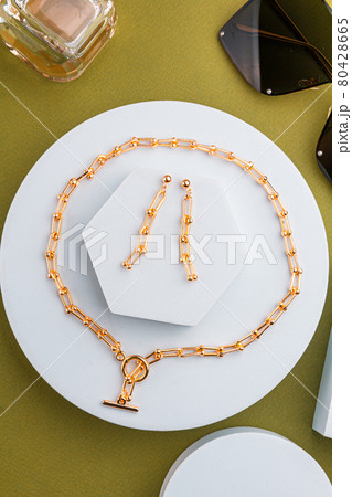 costume jewelry on white geometric figures earrings, chain on a green background costume jewelry on white geometric figures earrings, chain on a green background 80428665