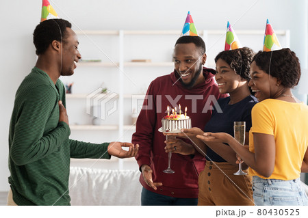 Happy black friends making surprise for birthday guy 80430525