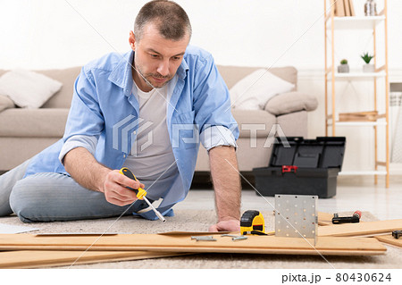 Man Fixing Wooden Cabinet Using Screwdriver And Carpentry Tools Indoor Man Fixing Wooden Cabinet Using Screwdriver And Carpentry Tools Indoor 80430624