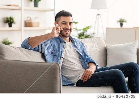 Portrait of smiling israeli man talking on phone at home 80430709