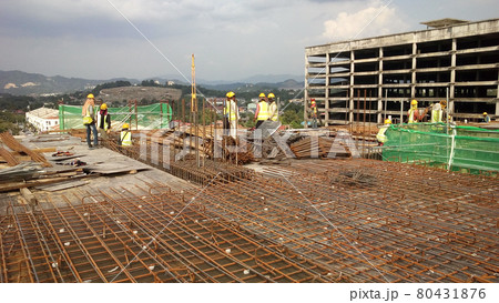 KUALA LUMPUR, MALAYSIA -NOVEMBER 23, 2020: Building floor slab under construction. Construction workers fabricating the timber formwork and installing the steel reinforcement bar.  80431876