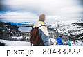 A man camping on a mountain looking at snow. 80433222