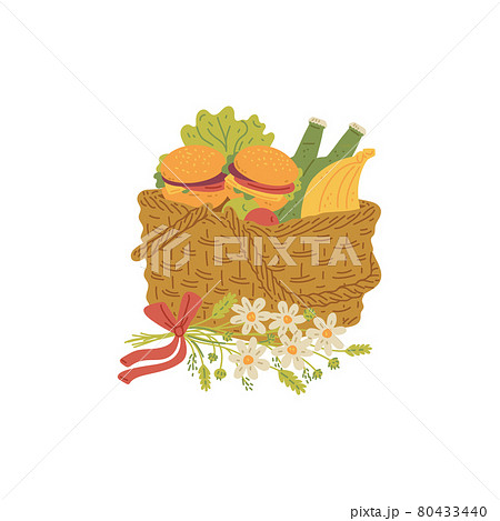 Wicker picnic basket with fresh food for lunch outdoor decorated flowers. 80433440
