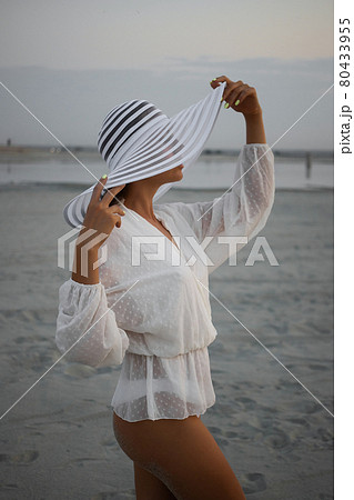 Stylish sensual woman in beachwear and hat Stylish sensual woman in beachwear and hat 80433955