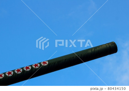 The barrel of a large-caliber artillery gun. Five-pointed stars on the trunk. Soviet weapons. Military equipment. The muzzle is directed to the right and up The barrel of a large-caliber artillery gun. Five-pointed stars on the trunk. Soviet weapons. Military equipment. The muzzle is directed to the right and up 80434150