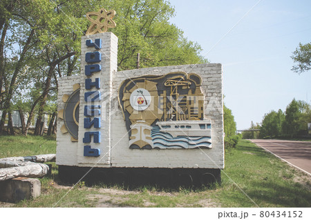 Stella with the Chernobyl road sign at the entrance to the city. Exclusion Zone 80434152