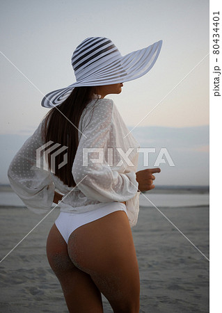 Stylish sensual woman in beachwear and hat Stylish sensual woman in beachwear and hat 80434401