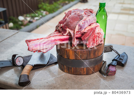 Raw meat on a deck for making lunch. Fresh meat on a cutting board with olive oil and a knife. 80436973