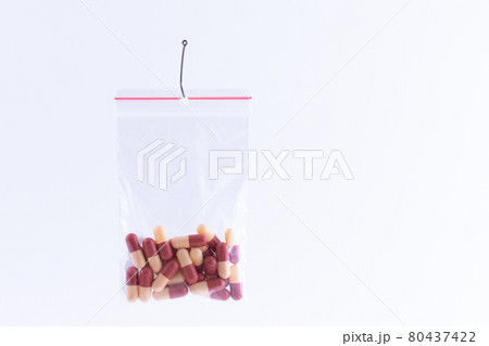 Colored Pills or Tablets Hanging in Small Ziplock Bag on a Fishing Hook 80437422