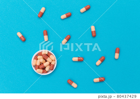 Pharmaceutical Industry and Medicinal Products - Colored Pills on Blue Table Pharmaceutical Industry and Medicinal Products - Colored Pills on Blue Table 80437429