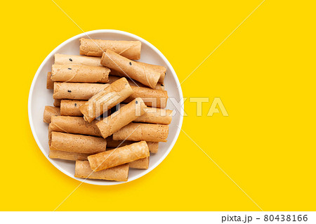 Thai crispy coconut rolls in white plate on yellow background. 80438166
