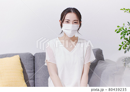 笑顔でマスクを着ける若い女性 80439235
