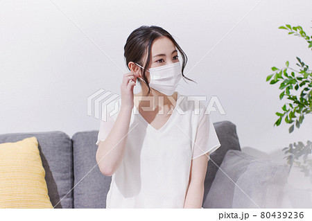 笑顔でマスクを着ける若い女性 80439236