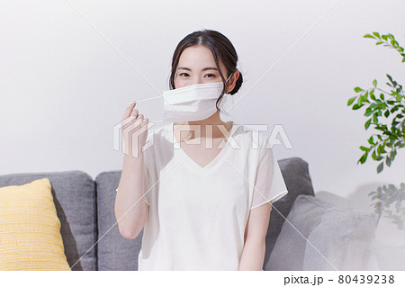 笑顔でマスクを着ける若い女性 笑顔でマスクを着ける若い女性 80439238