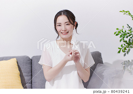 笑顔でマスクを着ける若い女性 80439241
