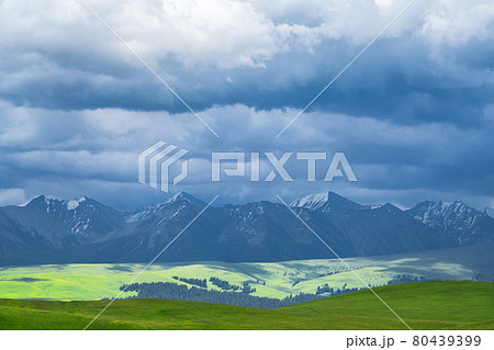 Grassland and mountains in a cloudy day. Photo in Kalajun grassland in Xinjiang, China. Grassland and mountains in a cloudy day. Photo in Kalajun grassland in Xinjiang, China. 80439399