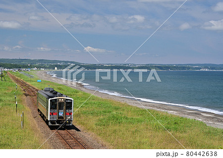 オホーツク海に一番近い釧網本線北浜駅から見る晴天の穏やかな夏のオホーツク海沿いを走る一両のローカル線 80442638