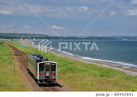 オホーツク海に一番近い釧網本線北浜駅から見る晴天の穏やかな夏のオホーツク海沿いを走る一両のローカル線 80442641