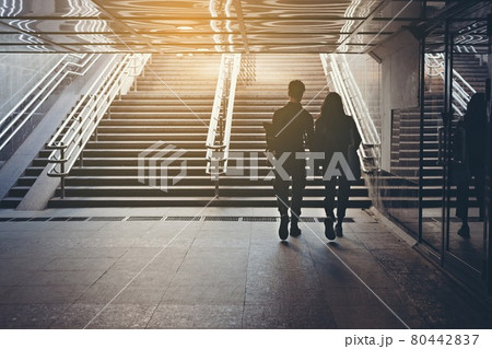Silhouettes of people. People in underground crossing. View from the back. Couple of young people on the crosswalk. The couple is holding hands and walking on the sity. Unknown people. Street photo 80442837