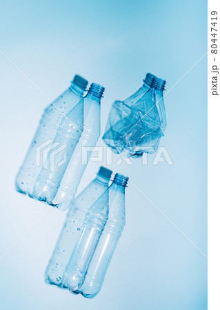 Plastic bottles with water and empty used on blue background. Recycling recyclable plastic. Environmental protection Plastic bottles with water and empty used on blue background. Recycling recyclable plastic. Environmental protection 80447419