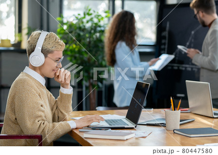 Young blond businesswoman looking at laptop display 80447580